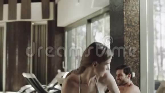 亲密性感的情侣坐在游泳池附近的躺椅上视频的预览图