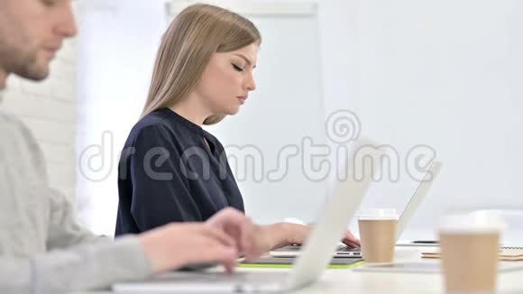 有创意的女人在笔记本电脑上工作办公室有颈部疼痛视频的预览图