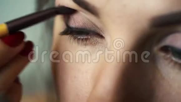 眼妆女人涂抹眼影粉完美的裸妆视频的预览图