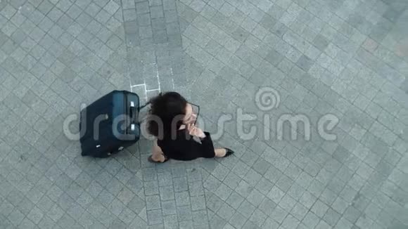 顶景女士带着手提箱走在户外戴太阳镜的女人视频的预览图