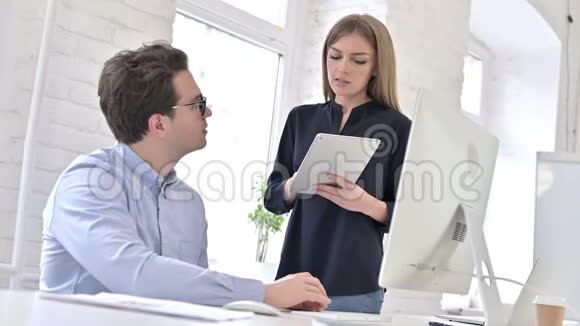 创意女性与男人在办公室使用桌面讨论视频的预览图