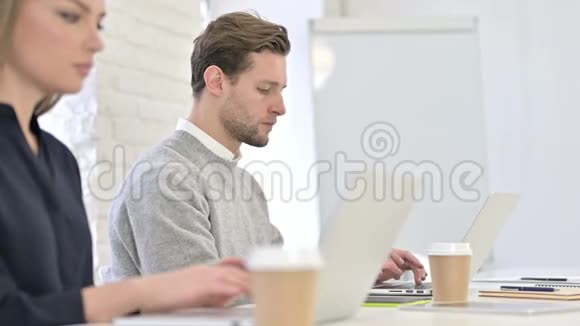 年轻的创意人在电脑上工作在镜头前微笑视频的预览图