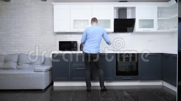 年轻的帅哥在厨房跳舞生活方式视频的预览图