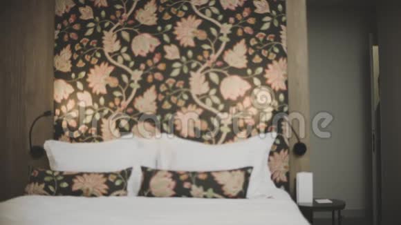 疲惫的男人走进豪华酒店的房间性感男人在现代卧室里跳床视频的预览图