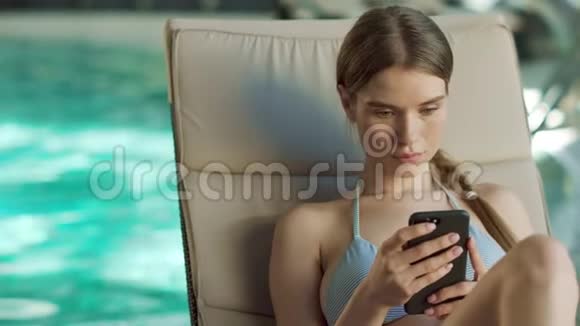 性感女人在泳池边用电话放松的肖像漂亮女孩在移动视频的预览图