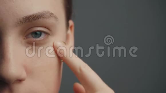 年轻女孩用手指在脸上打粉底视频的预览图
