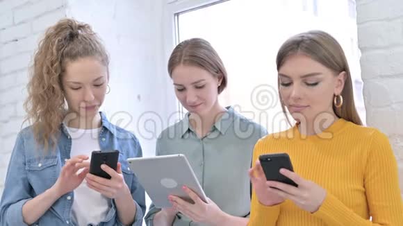 使用智能手机和平板电脑的快乐女性创意团队视频的预览图