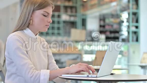 一位年轻女子在咖啡馆的智能手机上生气视频的预览图