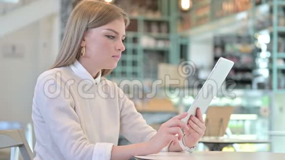 咖啡馆里年轻女子在平板电脑上的视频聊天视频的预览图