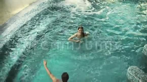 在泳池里玩得开心的幸福夫妇的俯视图微笑的情侣在泳池里嬉戏视频的预览图