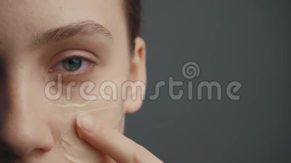 年轻女孩把遮瑕膏放在脸上视频的预览图
