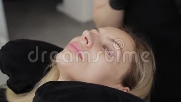 一位美容院的专业美容师将睫毛层压凝胶应用于客户的睫毛上视频的预览图