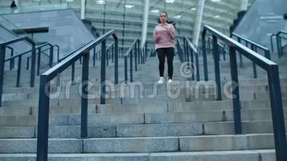 运动的女人从户外楼梯上跑下来跑步的女人从楼梯上慢跑视频的预览图