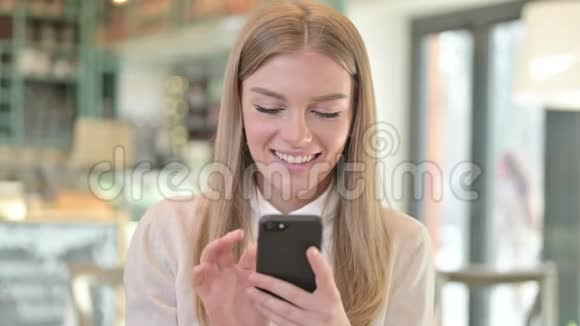 快乐年轻女性使用智能手机的画像视频的预览图
