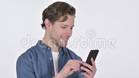 在白色背景下使用智能手机的专注青年画像视频的预览图