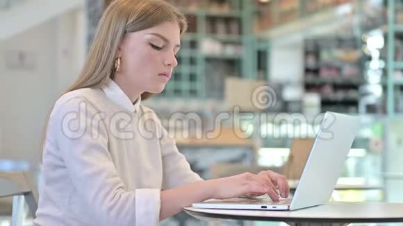 在咖啡馆里使用笔记本电脑的年轻女子震惊的表情视频的预览图