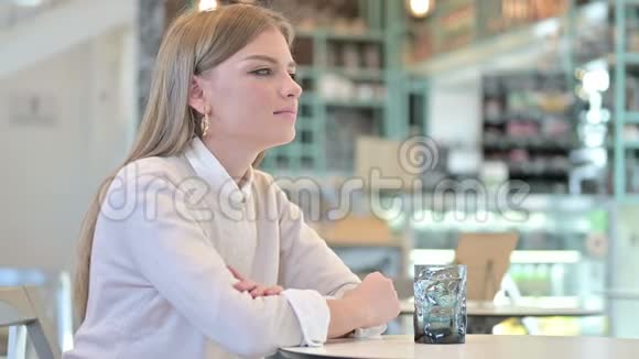健康的年轻女子在咖啡馆里喝水视频的预览图