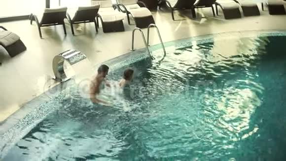 年轻夫妇在游泳池里享受水疗豪华水疗中心的快乐情侣视频的预览图