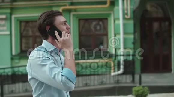 商人在用手机说话穿着衬衫的男人在街上打电话视频的预览图