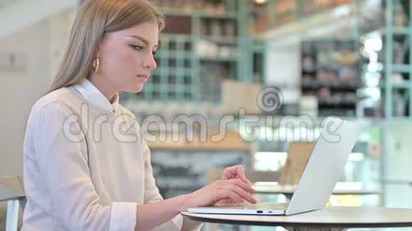 咖啡馆里年轻女子的笔记本电脑视频聊天视频的预览图