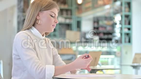 职业青年妇女在咖啡厅写纸视频的预览图