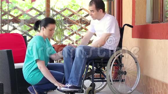 女护士安慰坐在轮椅上的悲伤男子视频的预览图