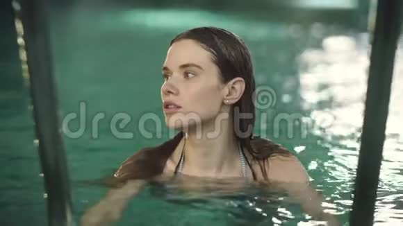 在游泳池游泳的漂亮女人性感的女孩看着镜头视频的预览图