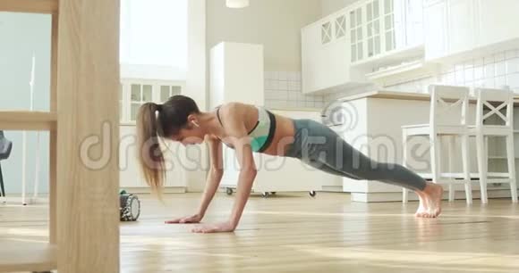 在家练习瑜伽运动中女人练习面向狗姿势视频的预览图