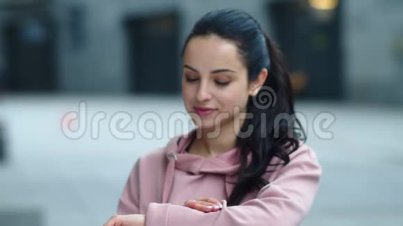 微笑的女人触摸智能手表屏幕把漂亮女孩的留言合上视频的预览图