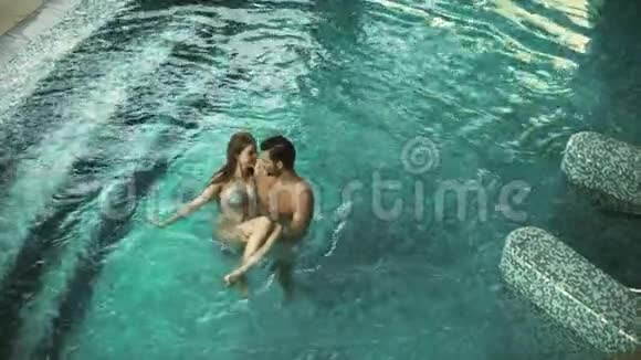 幸福夫妇享受游泳池的最高景观欢乐的一对在健康的酒店放松视频的预览图
