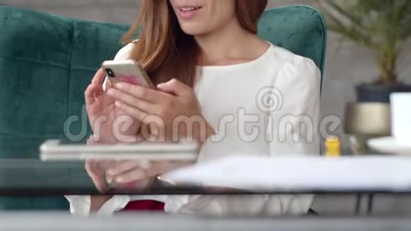 微笑商务女性在办公室滚动手机使用智能手机的女孩视频的预览图