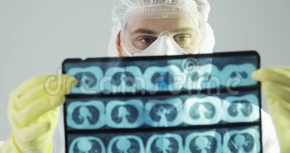 穿着防护服的医生在covid19上学习大脑CT扫描x射线图像视频的预览图