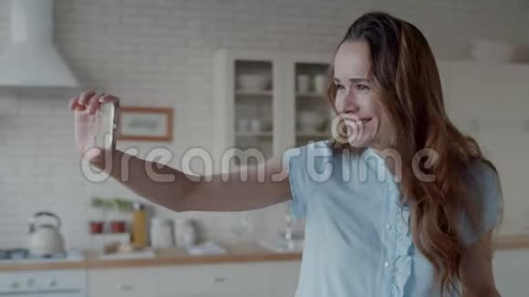 快乐的女人在现代厨房自拍照片女孩摆姿势拍照视频的预览图