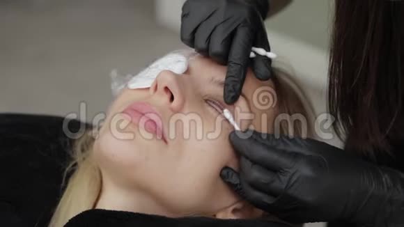 一位美容院的专业美容师将睫毛层压凝胶应用于客户的睫毛上视频的预览图