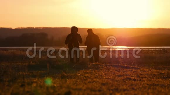 两个朋友夕阳西下往前走探险旅行的概念肩上背着一个背包视频的预览图