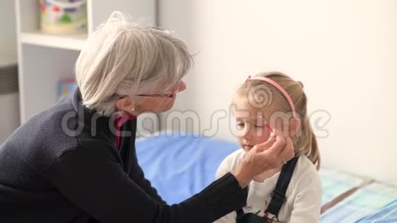 祖母和孙女一起玩祖母用孩子们的化妆她的脸视频的预览图