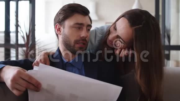 有魅力的家庭夫妻在家讨论生意一对拥抱在沙发上视频的预览图