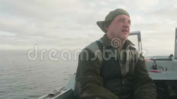 船上的白人渔夫他很累但很满意美丽的水面和天空是背景视频的预览图