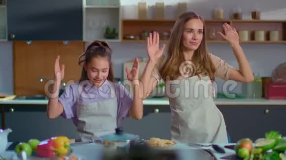 快乐的女孩和女人像机器人一样慢动作在厨房里跳舞视频的预览图
