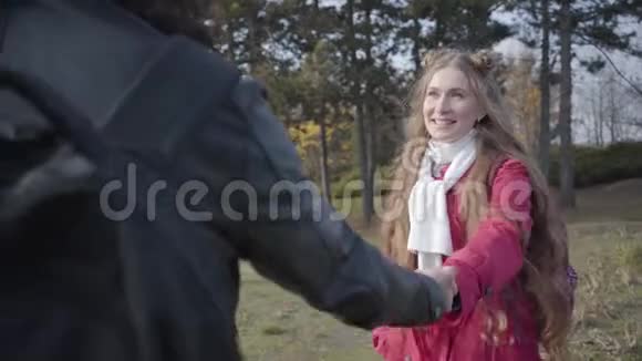 年轻美丽的白种人女孩的肖像引领着一个无法辨认的长发男人微笑的女人抱着男朋友视频的预览图