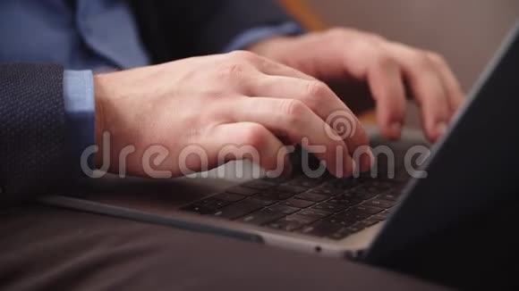 在家庭办公室的笔记本键盘上特写男手打字使用笔记本电脑的人视频的预览图