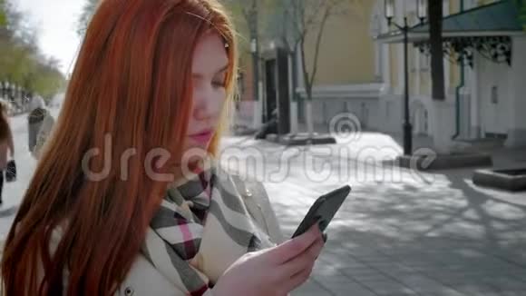 城市街道上美丽的年轻女子的肖像她在智能手机上和她的朋友交谈漂亮姑娘视频的预览图
