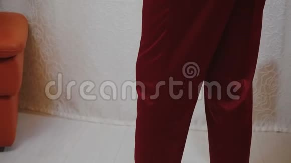 一个穿着红色丝绸睡衣双臂交叉摆姿势的男人的视频视频的预览图