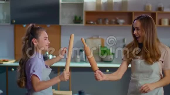 快乐的女儿和母亲在家厨房里打着滚针视频的预览图