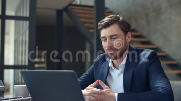 快乐的商人在笔记本电脑摄像头上打网络电话打电话的家伙视频的预览图
