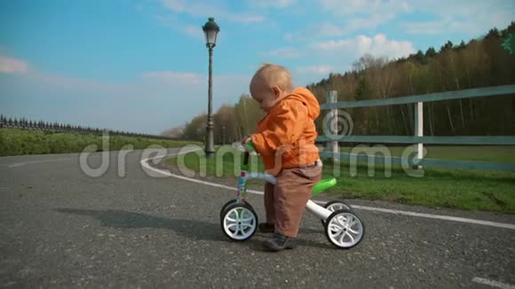 小孩骑着自行车慢动作过马路专注于骑自行车的男孩视频的预览图