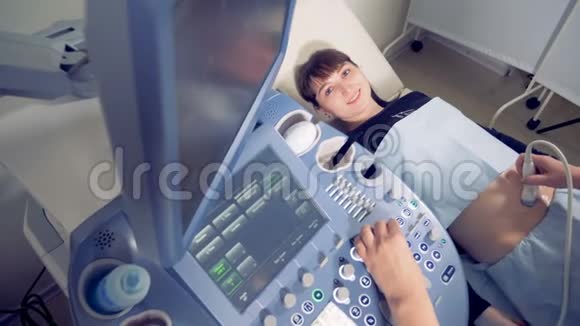 一位年轻孕妇接受超声检查的俯视图视频的预览图