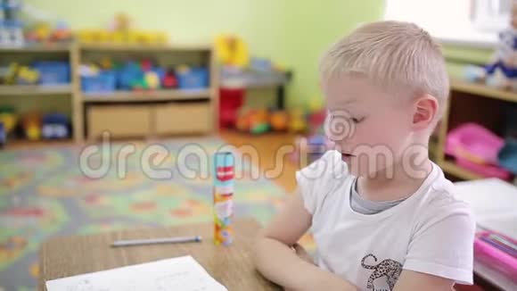 一个穿格子衬衫的男孩坐在相机前的椅子上衣服上有麦克风回答问题视频的预览图