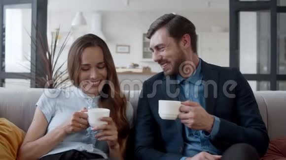 幸福的一家人在家喝茶成功的夫妻在沙发上聊天视频的预览图