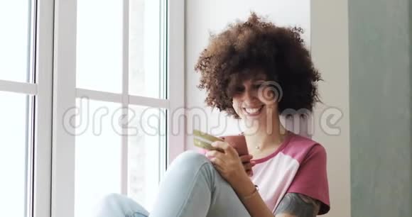 女人在家里用智能手机在线支付银行卡视频的预览图